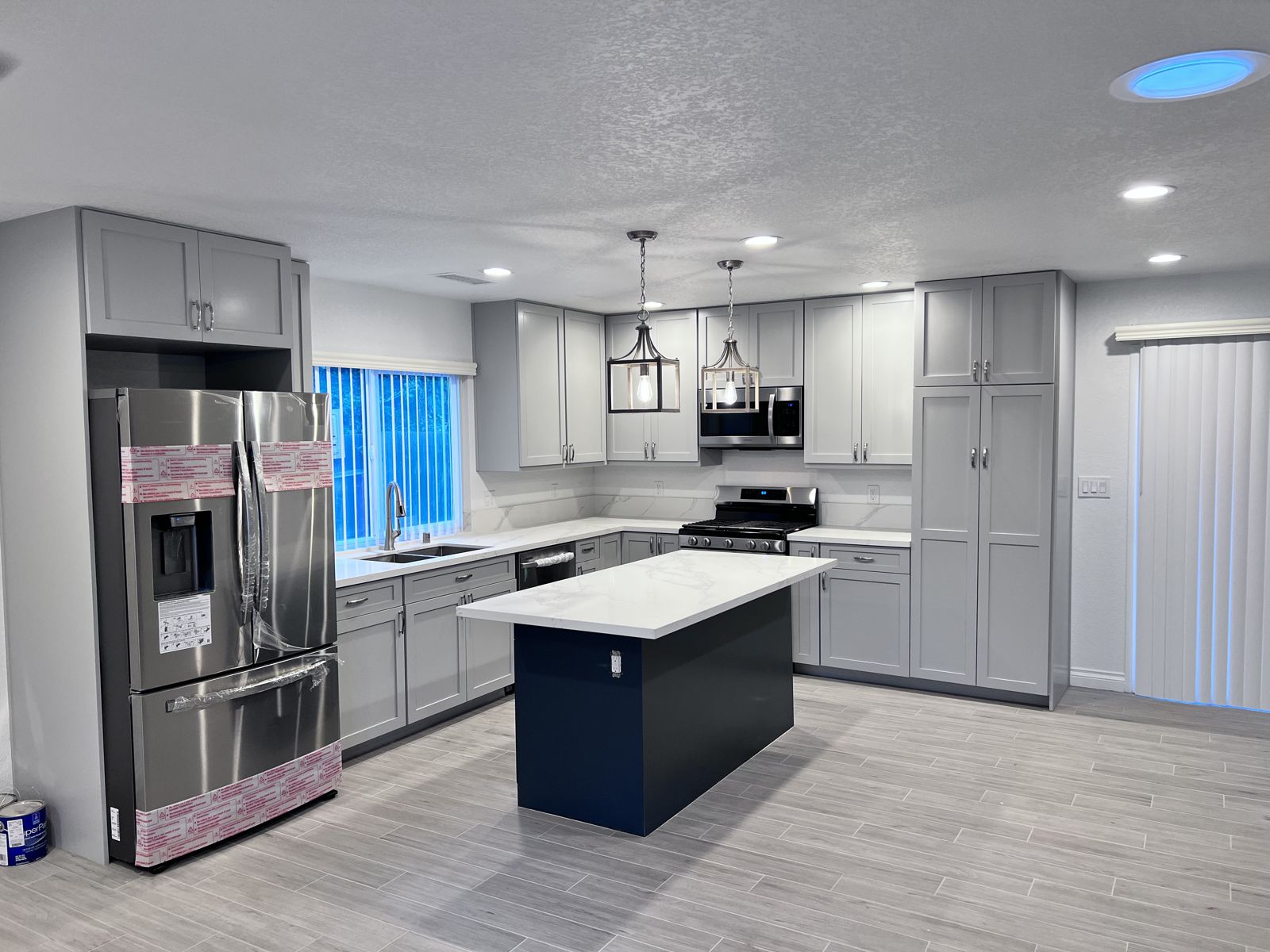 Finished gray shaker kitchen with navy island